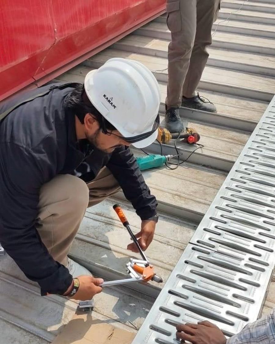 An AS Solar technician torquing a mounting rail onto a metal roof